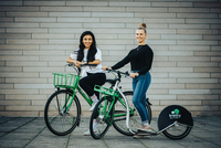 Zwei Frauen stehen auf einem Sharing-Roller der Firma Tretty