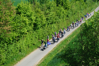Oblique aerial view of the cycling group on a car-free section of the route in the countryside.