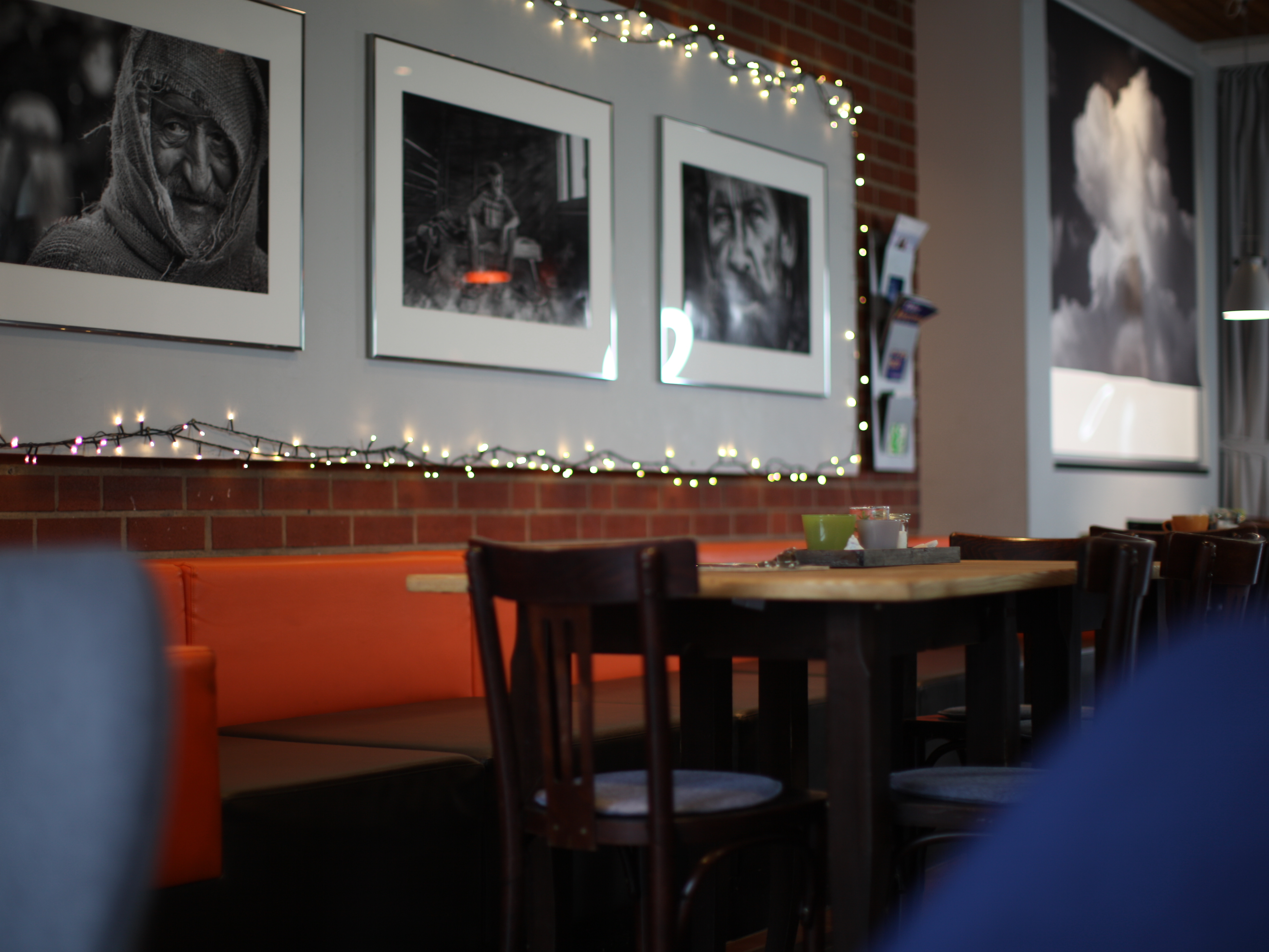 Sitzplätze im Café-Lorenz; an der Wand große schwarz-weiß Fotografien