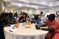 Vernetzungstreffen in Accra, fünf Personen sitzen am Tisch