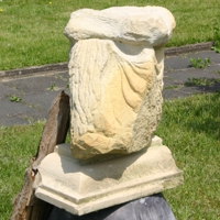Ansammlung von verschiedenen Steinen und einem Stück Treibholz, die an eine Figur erinnern