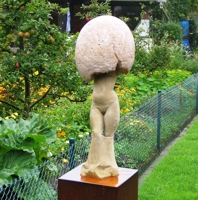 Sandsteinskulptue eines Frauenkörpers, dessen obere Hälfte durch ein überdimensionales Ei bedeckt ist