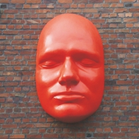 Überdimensionales rotes Gesicht mit geschlossenen Augen