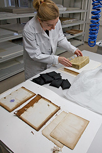 Eine Restauratorin restauriert beschädites Schriftgut im Restaurierungszentrum des Historischen Archivs in Köln