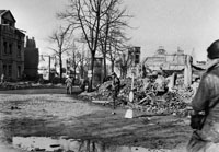 Amerikanische Soldaten auf einer Kreuzung inmitten von Trümmern.