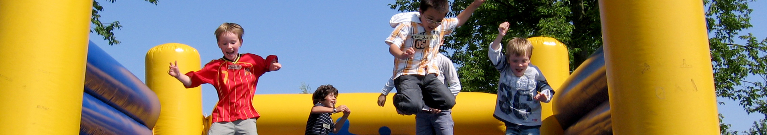 Kinder springen auf einer Hüpfburg wild umher
