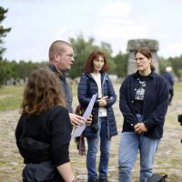 Gruppe von Teilnehmenden im Gespräch vor dem Gedenkmonument in Treblinka