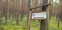 Gedenk- und Hinweisschild im Wald von Józefów