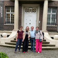 Vier Personen stehen für ein Gruppenbild vor der Villa ten Hompel und lächeln in die Kamera.
