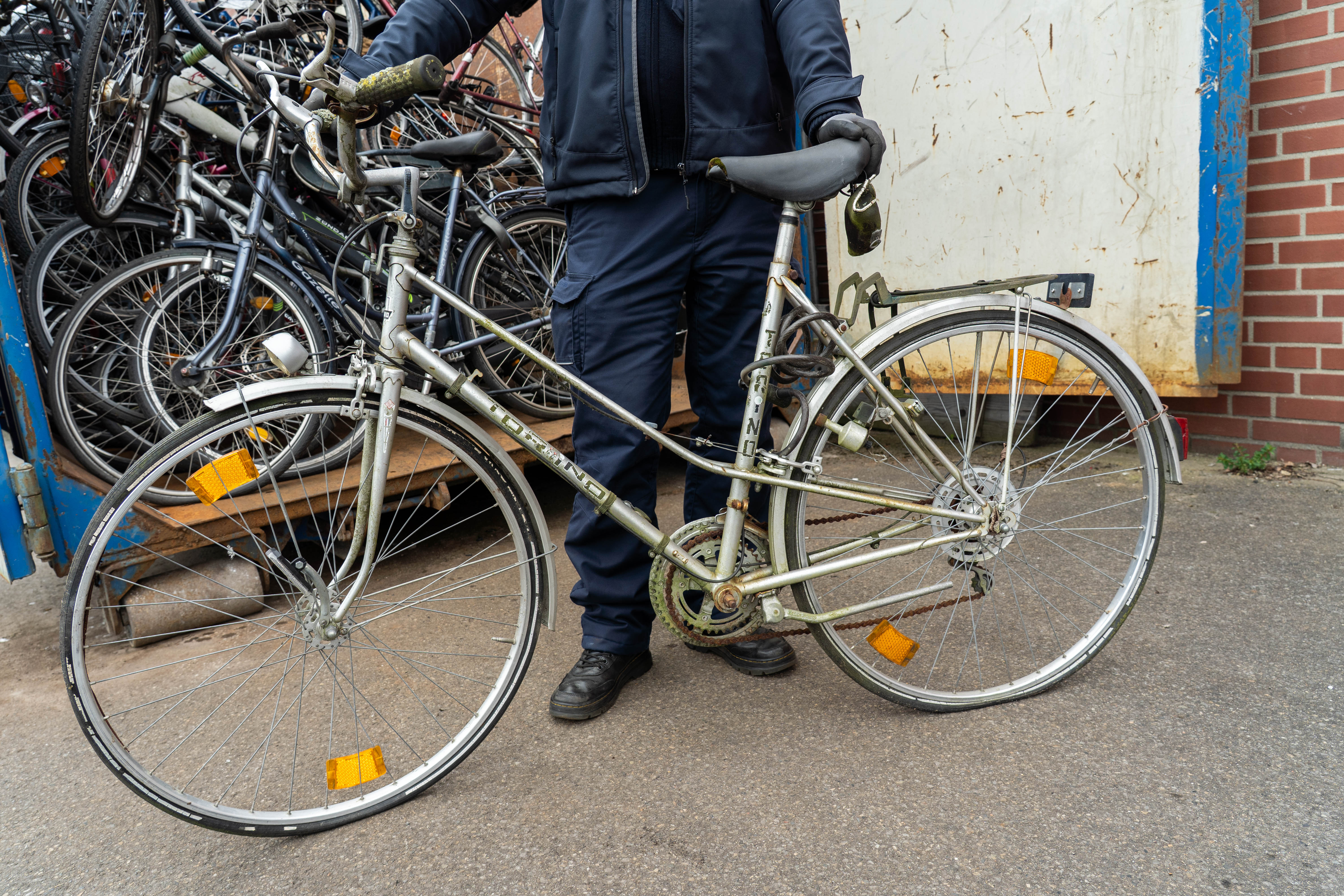 Ein städtischer Mitarbeiter präsentiert ein Schrottfahrrad.