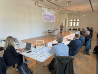 Beim Treffen von Münster Allianz für Klimaschutz sitzen die Teilnehmenden an Tischen in einem Konferenzraum.