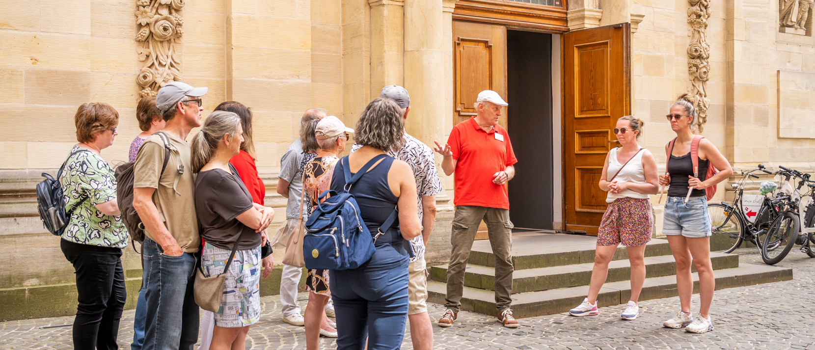 Stadtführer mit einer Gruppe vor der Dominikanerkirche