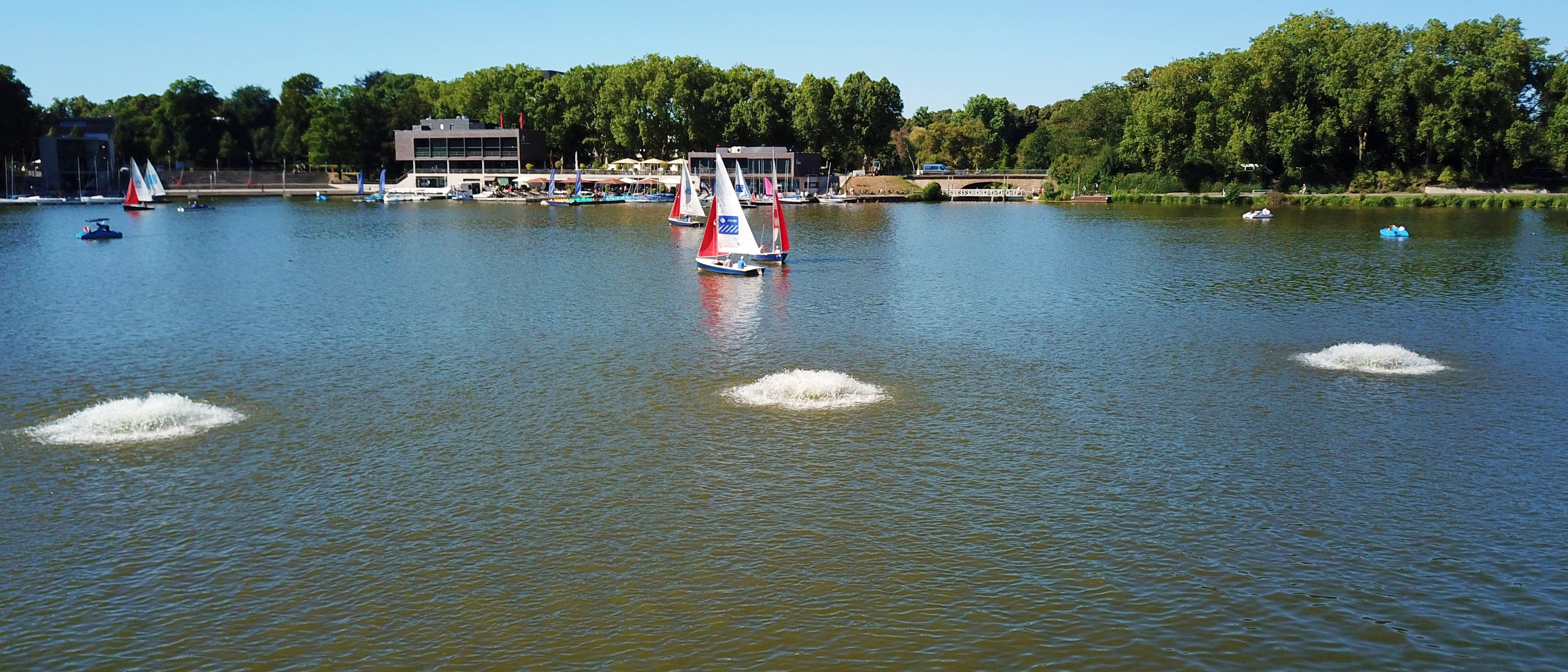 Mobile Belüftungsgeräte im Einsatz: Vier flache Wasserstrudel auf dem Aasee in Nähe des Ufers