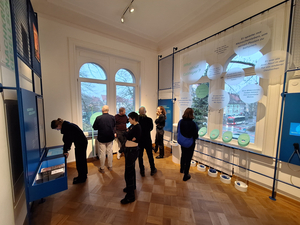 Eine Gruppe steht in einer Ausstellung zur Recherche