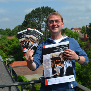 Stefan Querl zeigt Veranstaltungsflyer und Plakat
