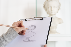 Eine Besucherin beim Zeichnen eines archäologischen Funds im Ausstellungsraum