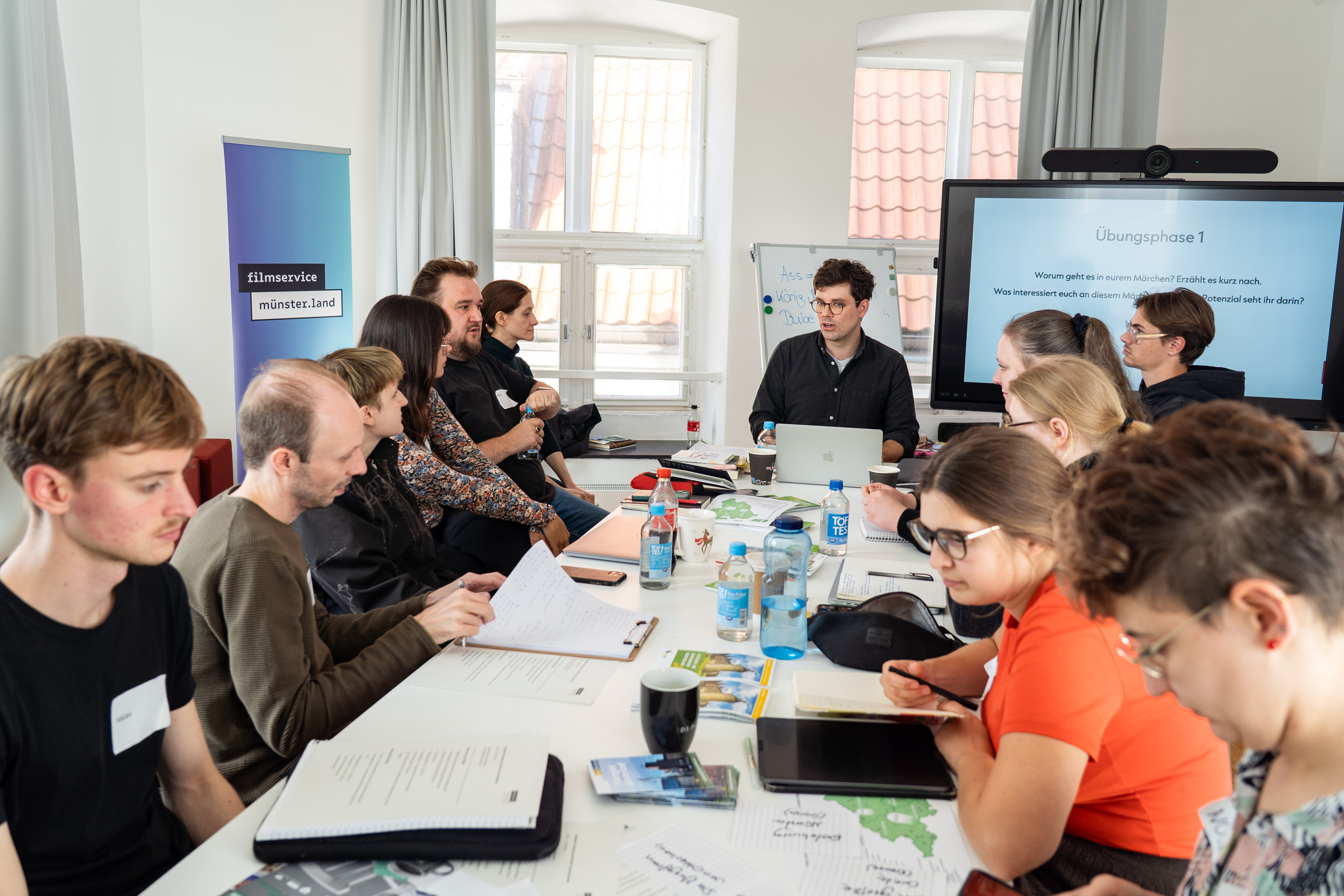 Viele Workshopteilnehmende sitzen am Tisch