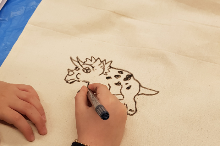 Eine Leinentasche wird mit einem Stift bemalt