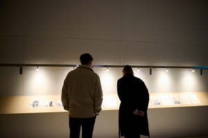 Zwei Personen sehen sich Kunstwerke an.