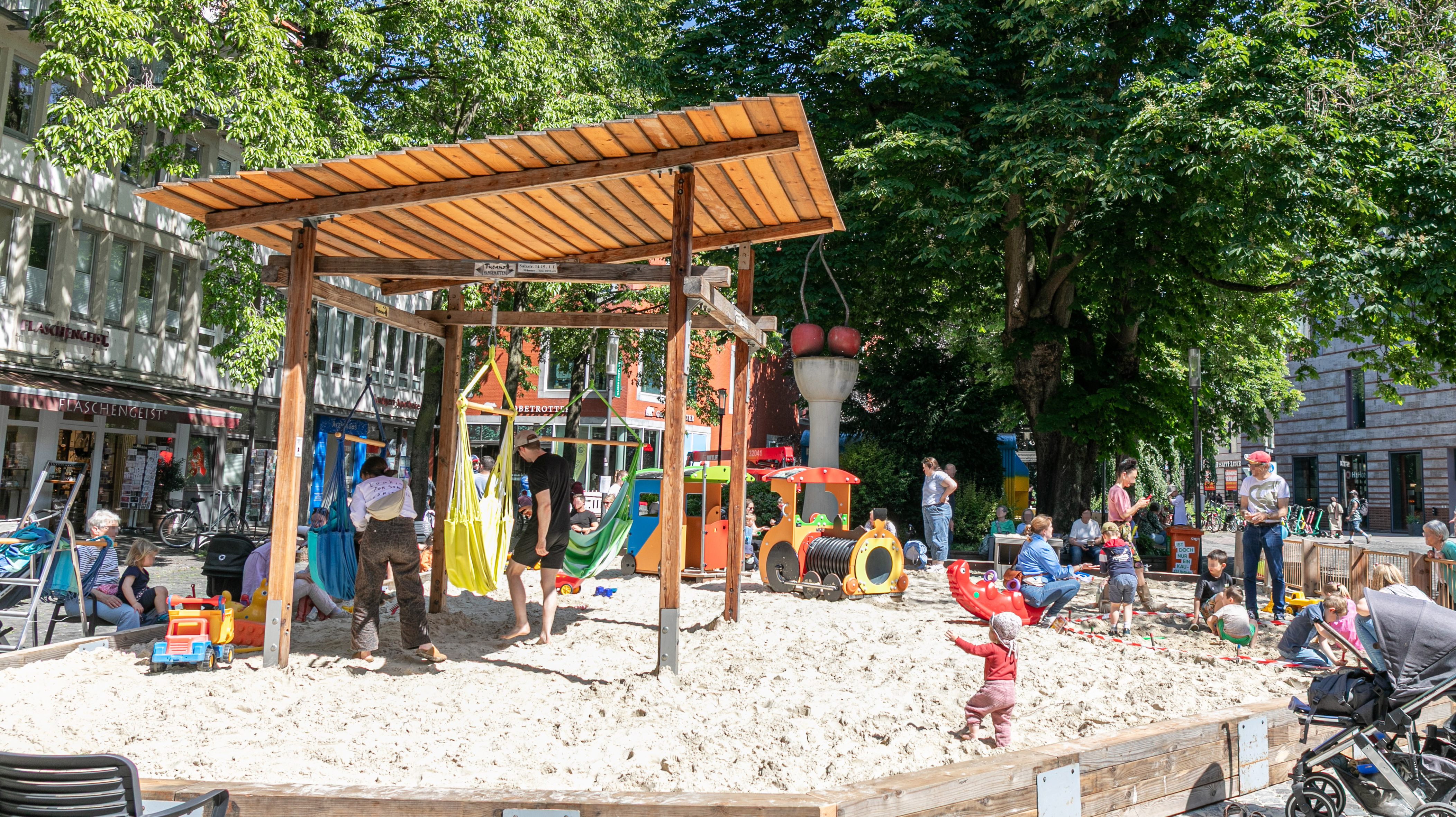 Großer Sandkasten in der Innenstadt mit spielenden Kindern