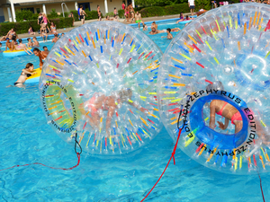 Das Bild zeigt zwei Wasserbälle, sogenannte Water Globes, in denen man sich über das Wasser fortbewegen kann.