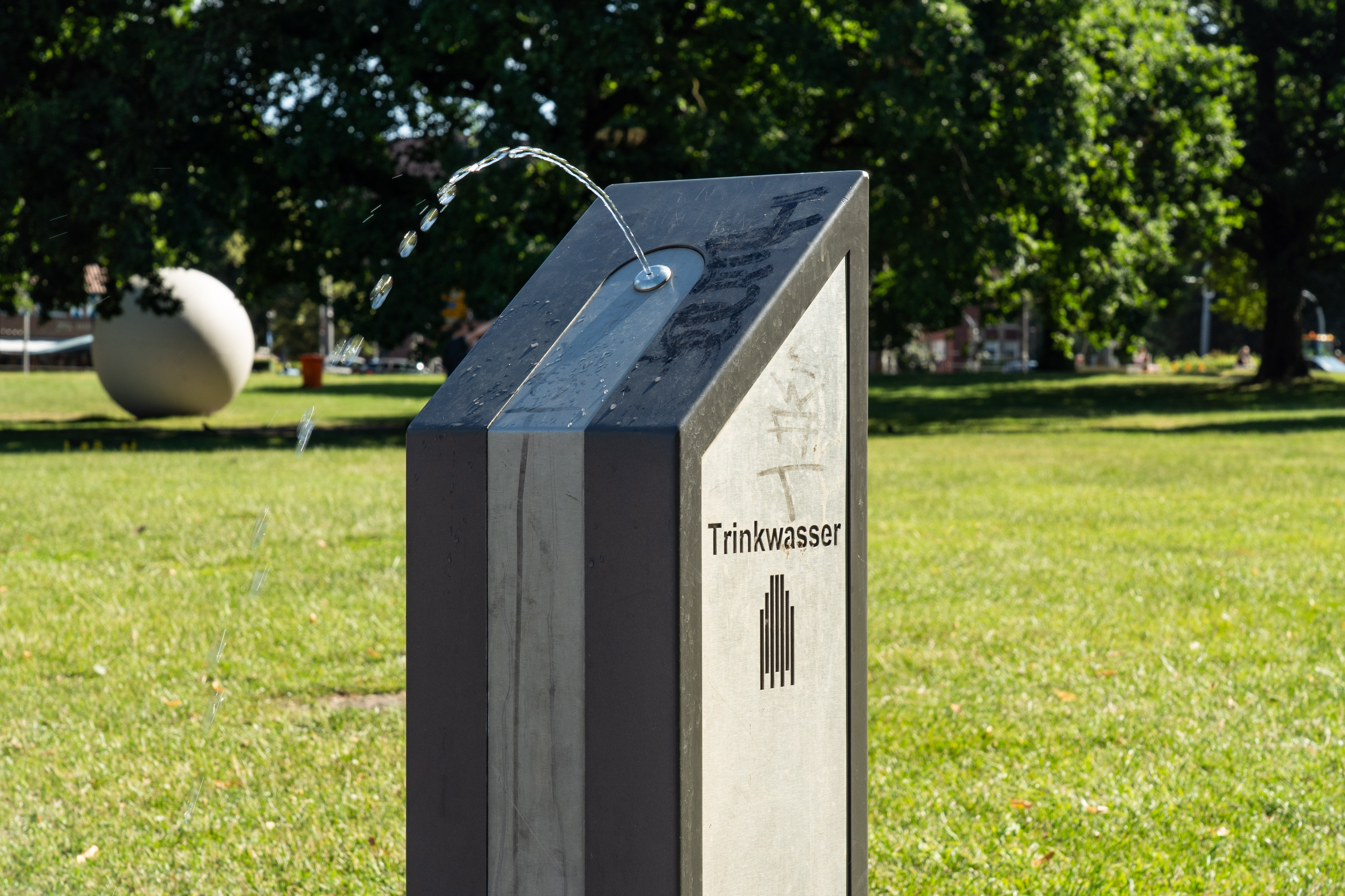 Trinkbrunnen vor einer grünen Wiese