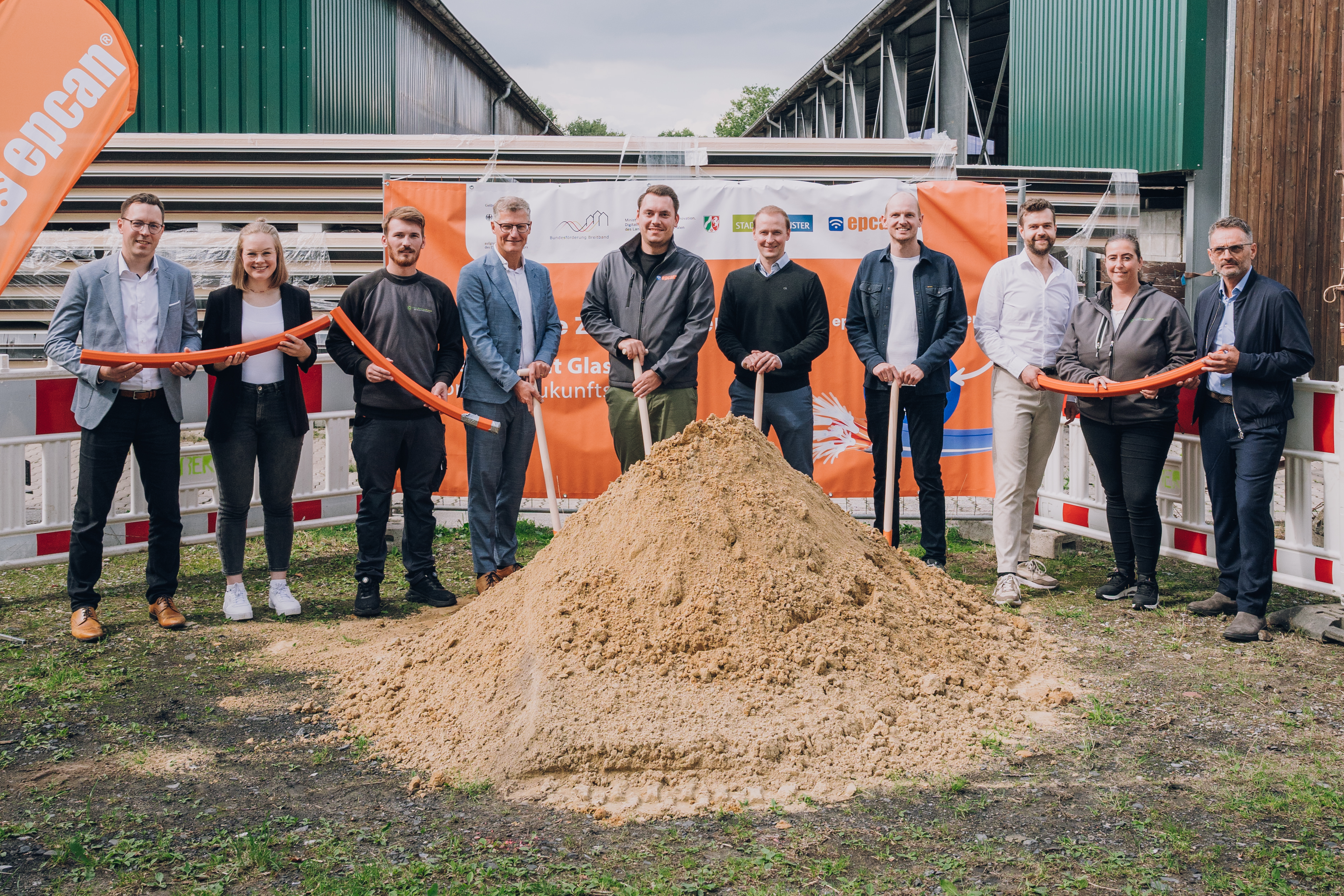 Gruppenbild mit Schaufeln und aufgehäuften Sand