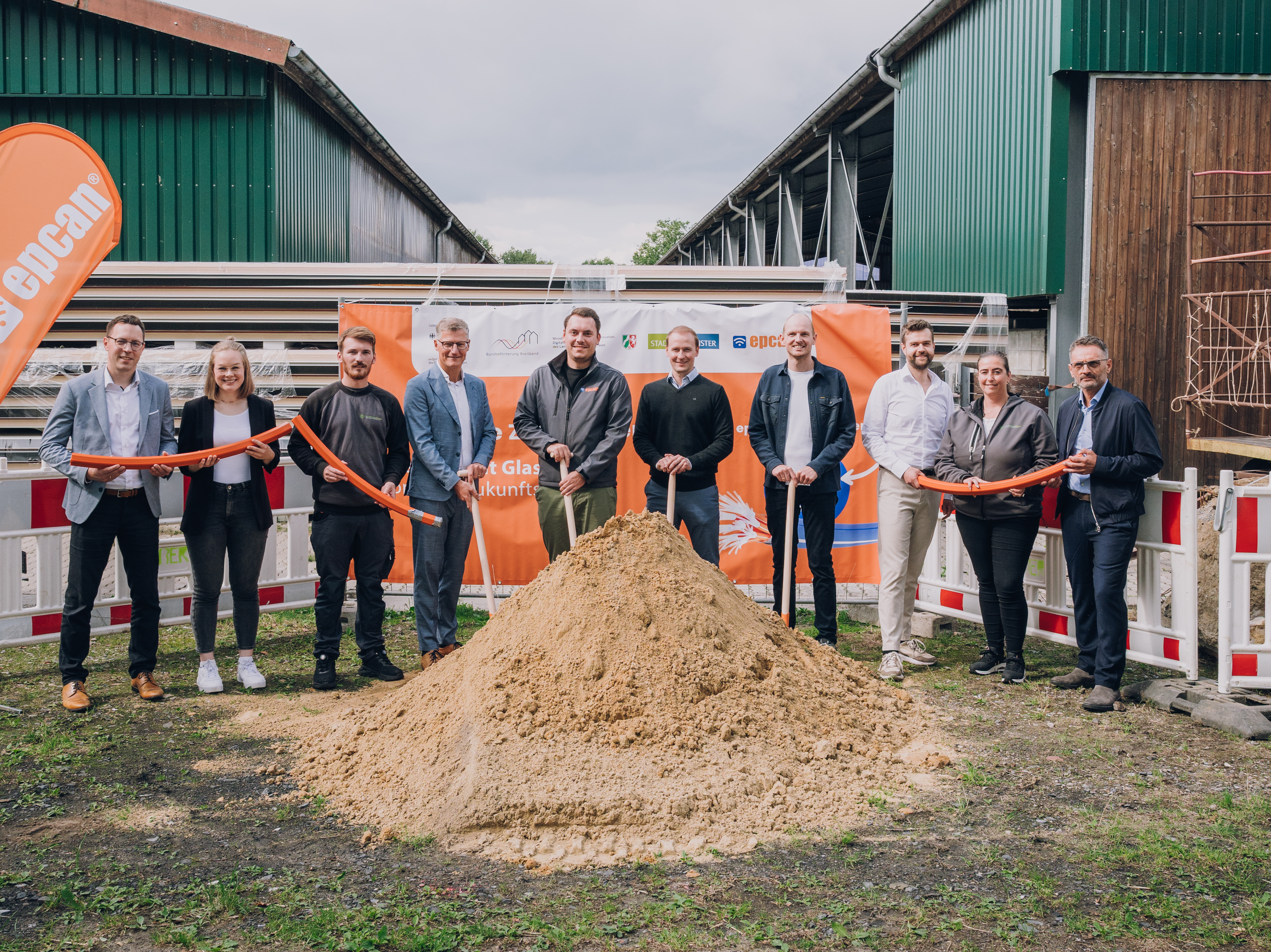 Gruppenbild mit Schaufeln und aufgehäuften Sand