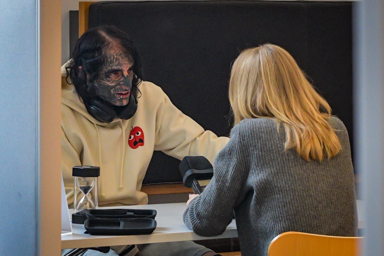 Ein stark tätowierter Mann im Gespräch.