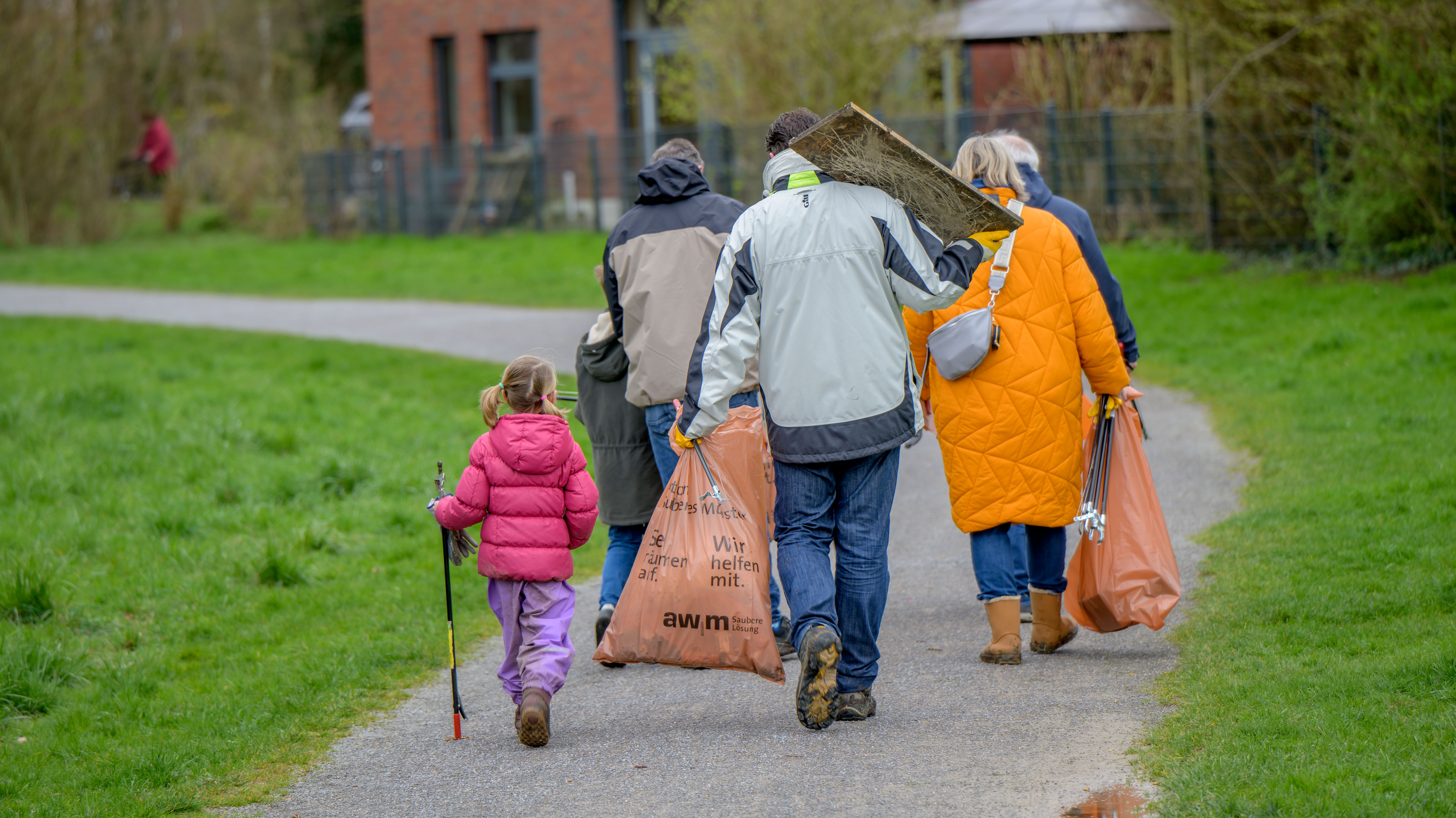 Teilnehmer der Aktion mit Abfallsäcken und Sammelzangen