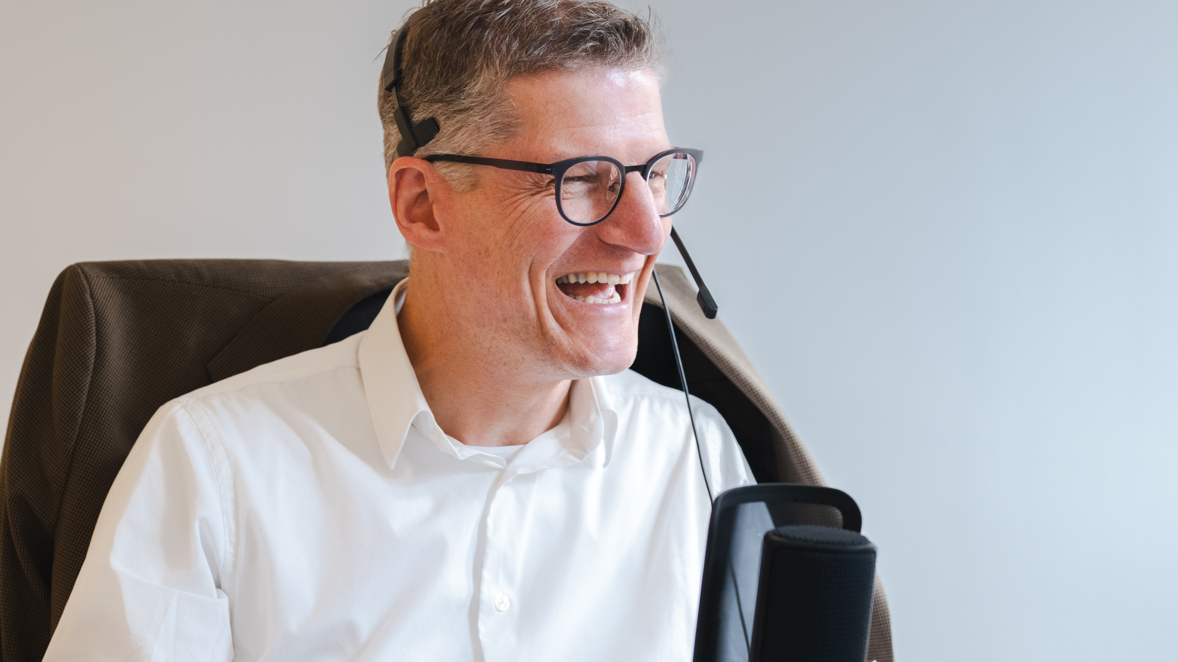 OB Tilman Fuchs sitzt hinter einem Mikrofon an einem Schreibtisch.