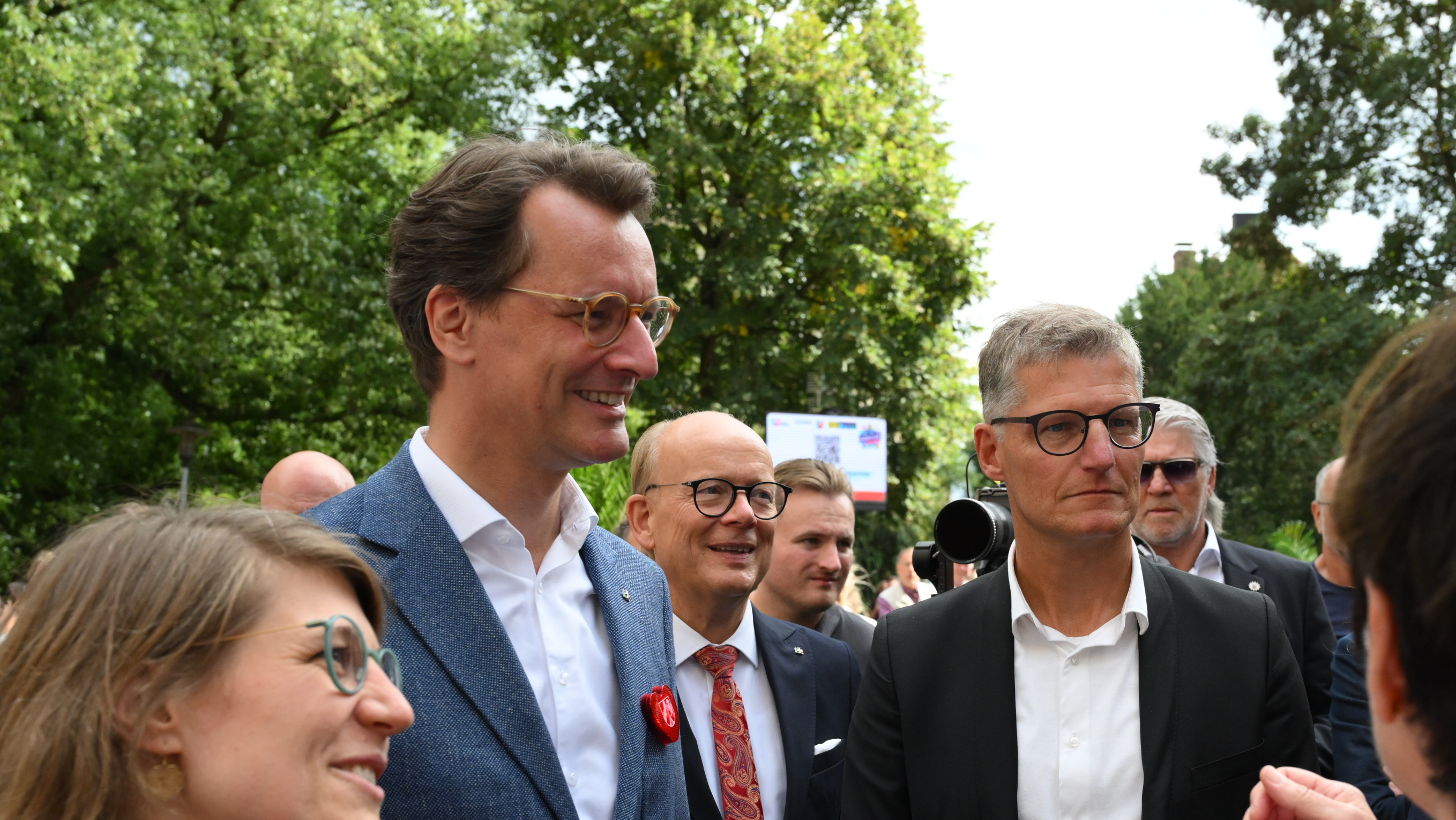 Ministerpräsident Hendrik Wüst und Oberbürgermeister Tilman Fuchs sowie weitere Personen auf einem Rundgang in der Innenstadt