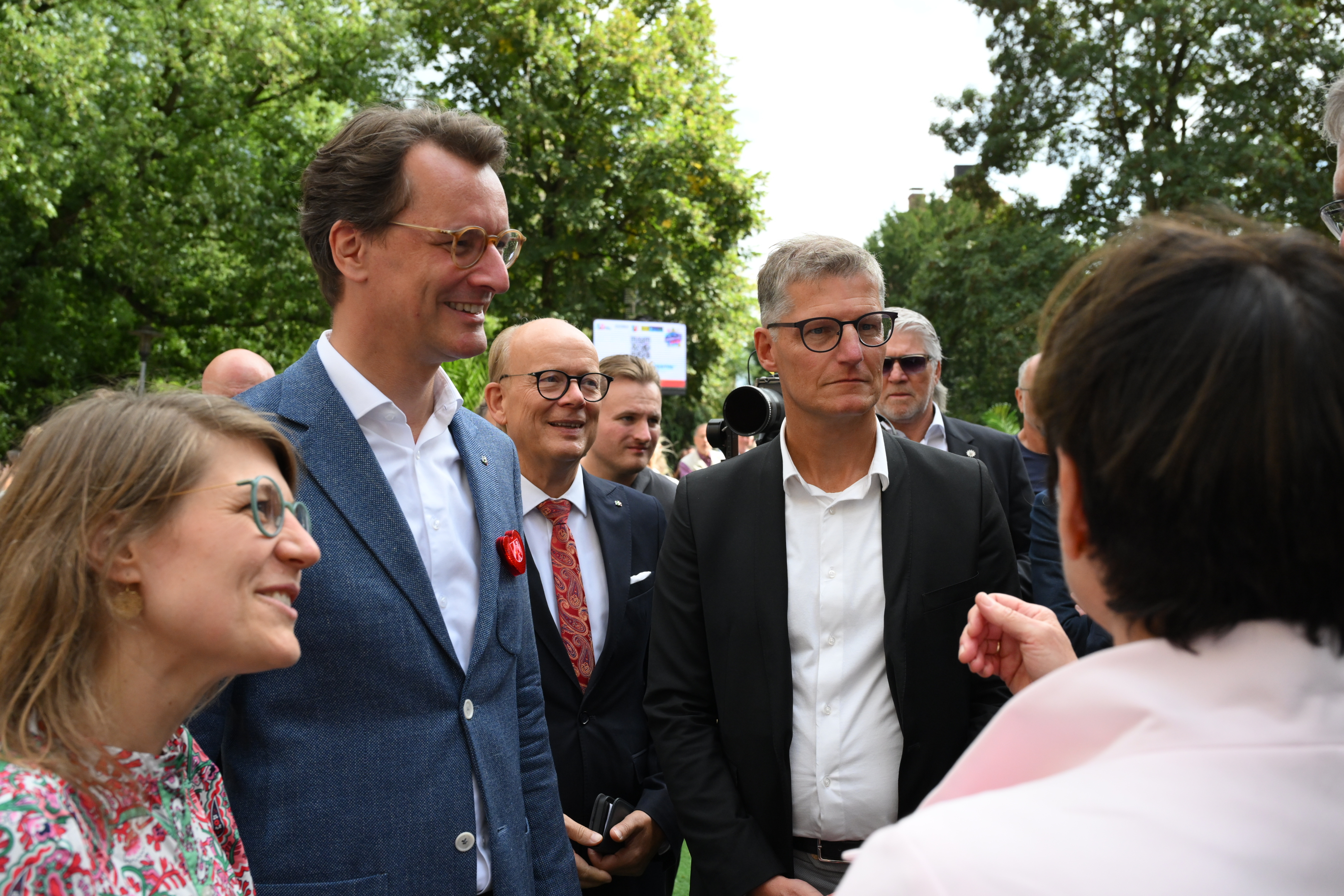 Ministerpräsident Hendrik Wüst und Oberbürgermeister Tilman Fuchs sowie weitere Personen auf einem Rundgang in der Innenstadt