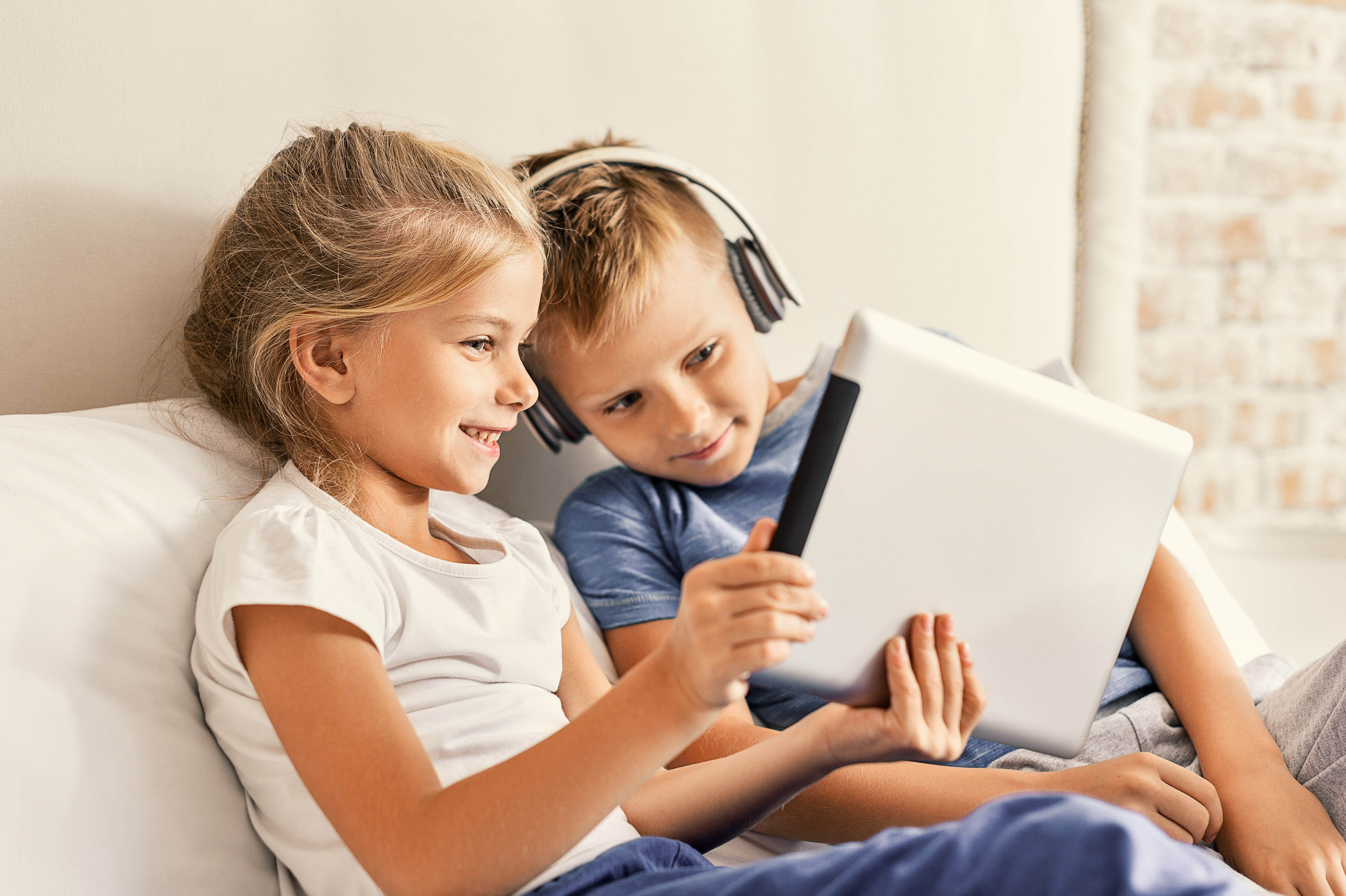 Zwei Kinder schauen auf ein Tablet.