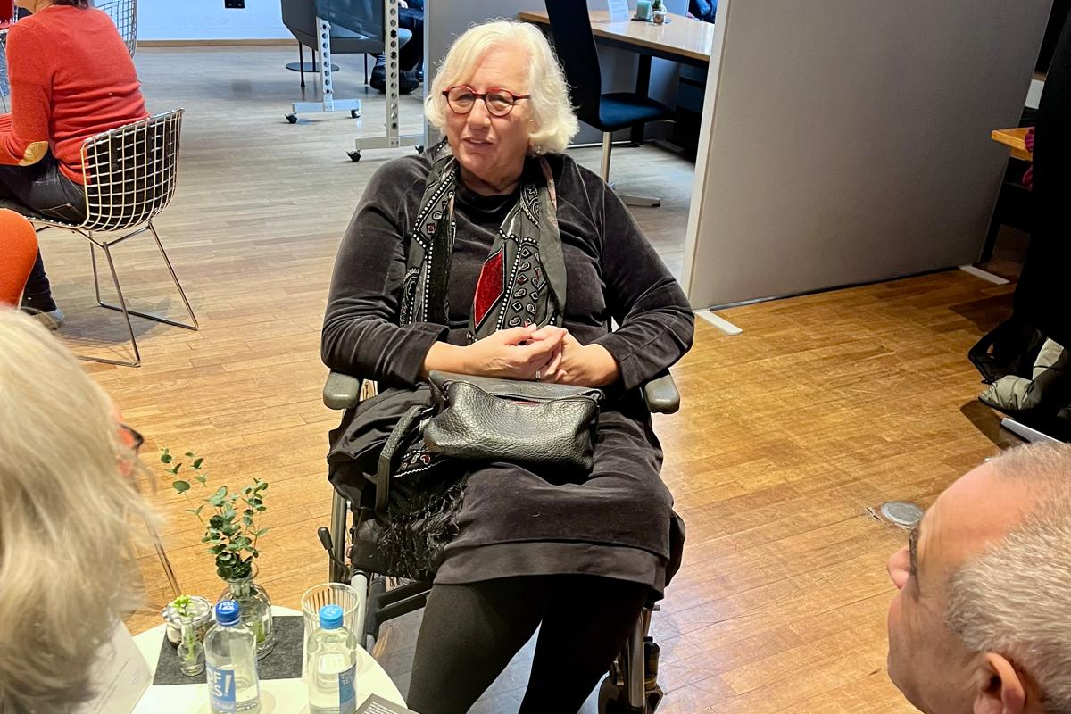 Human Library im Zeitungslesesaal der Stadtbücherei, eine Frau sitzt im Rollstuhl.