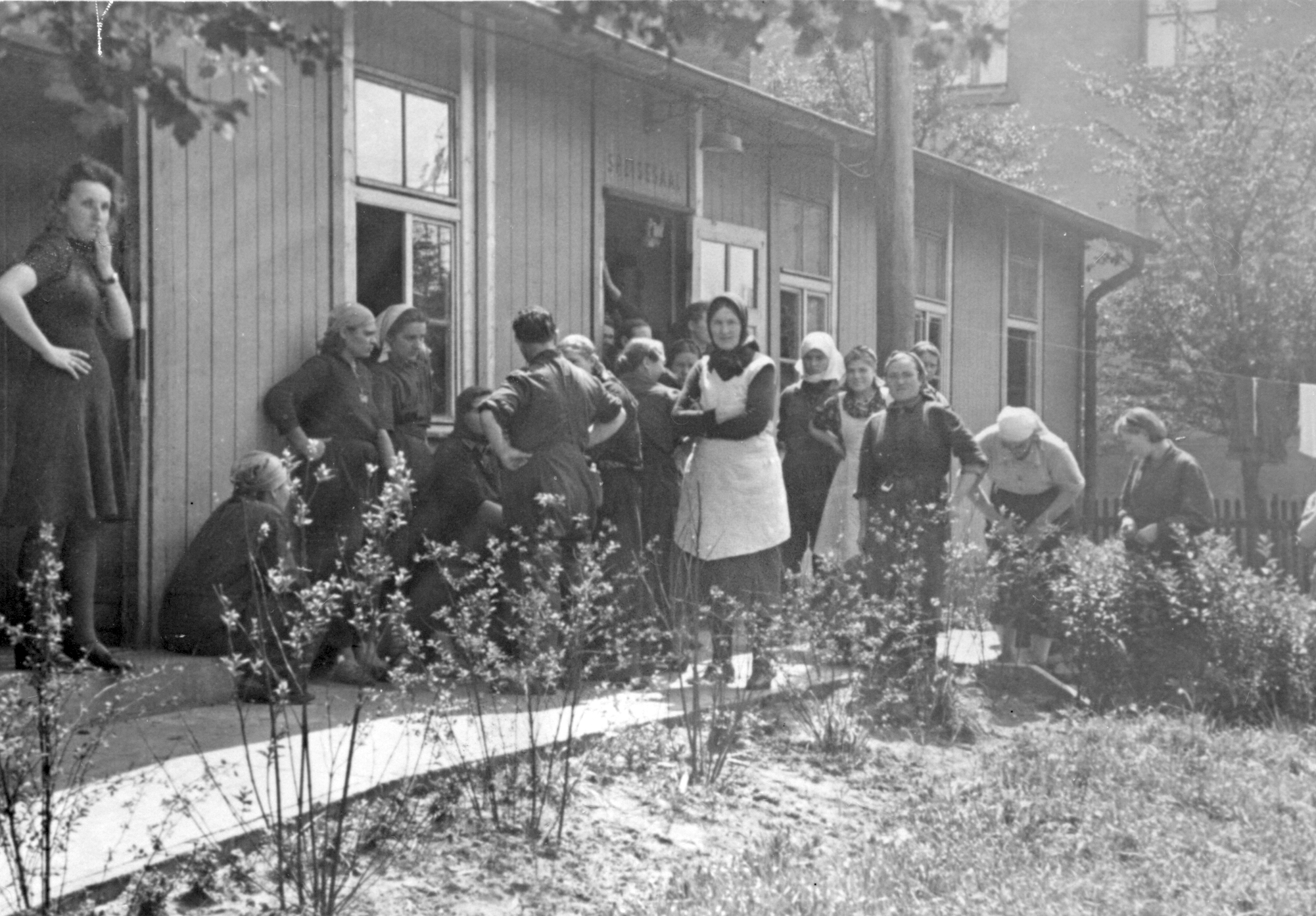 Mehrere Zwangsarbeiterinnen vor einer Baracke