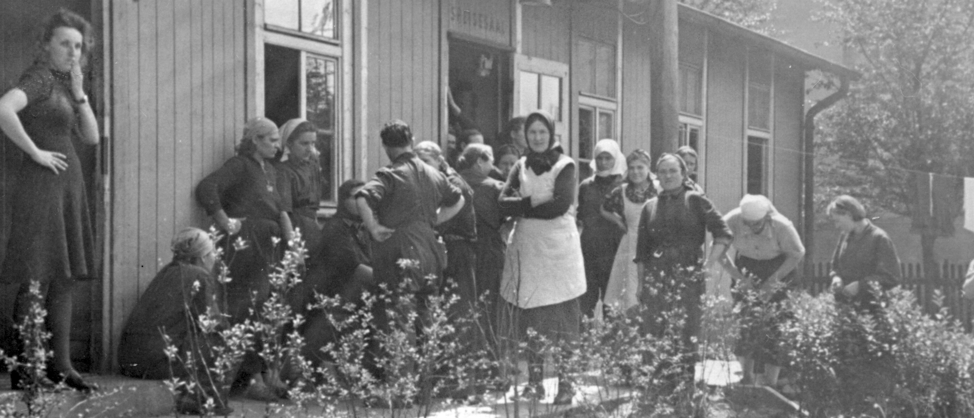 Mehrere Zwangsarbeiterinnen vor einer Baracke