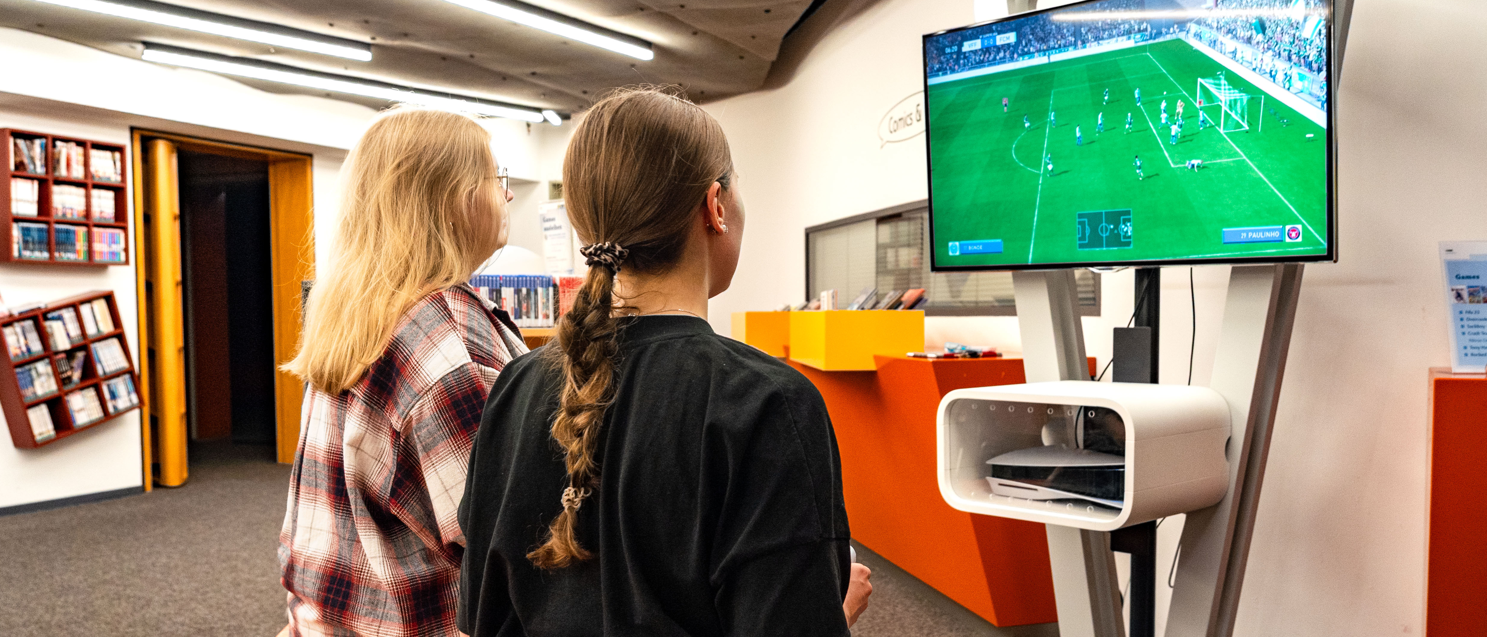 Zwei Mädchen spielen an der Playstation 5