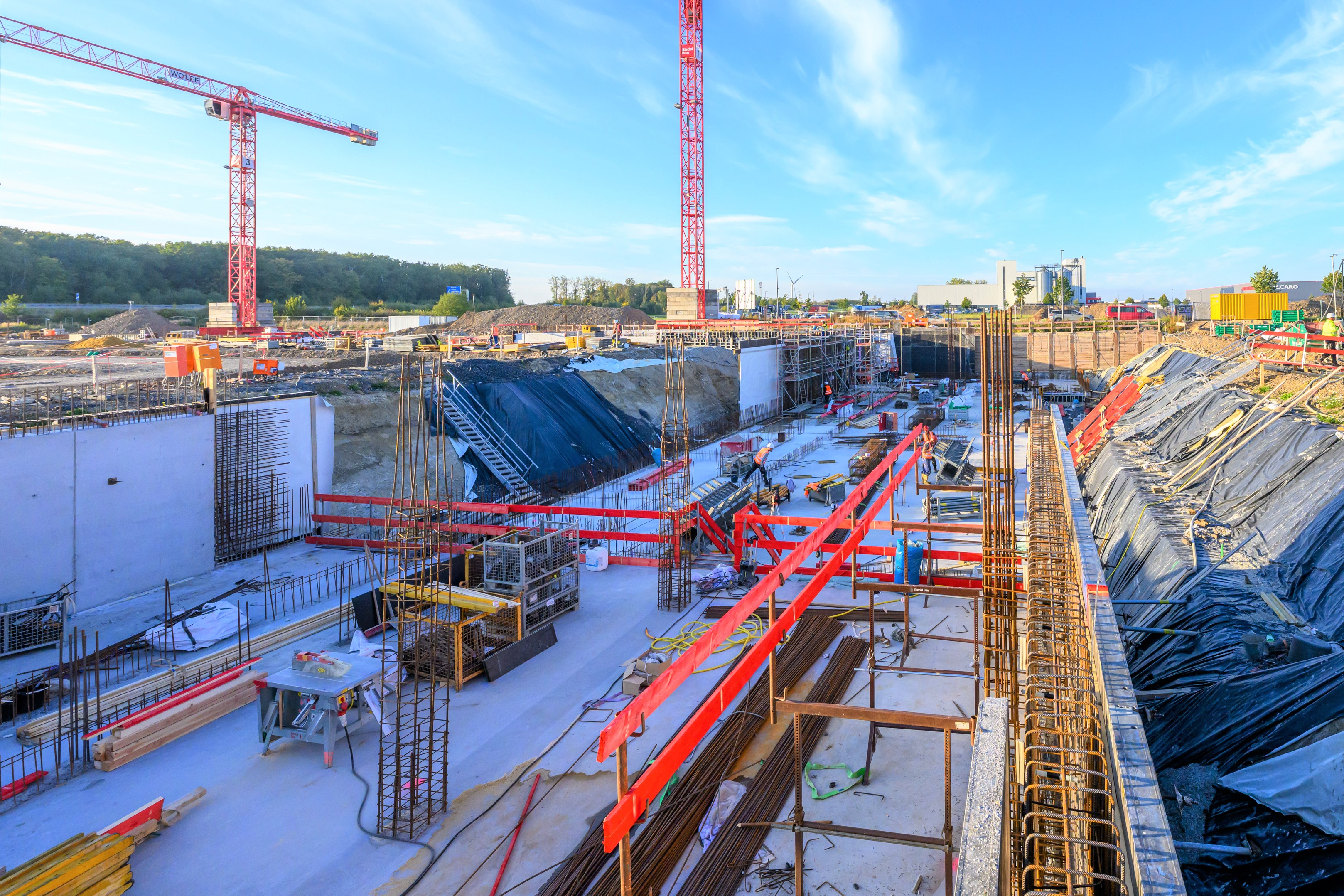 Blick auf eine Großbaustelle mit zwei Kränen