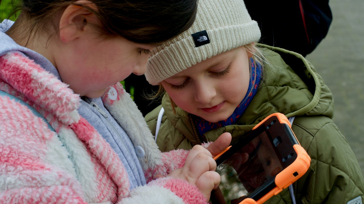 Zwei Kinder schauen auf ein Tablet