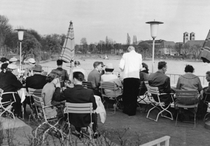 Gäste eines Cafés am Aasee in 1970er Jahren beobachten die Segelboote und bestellen beim Kellner.