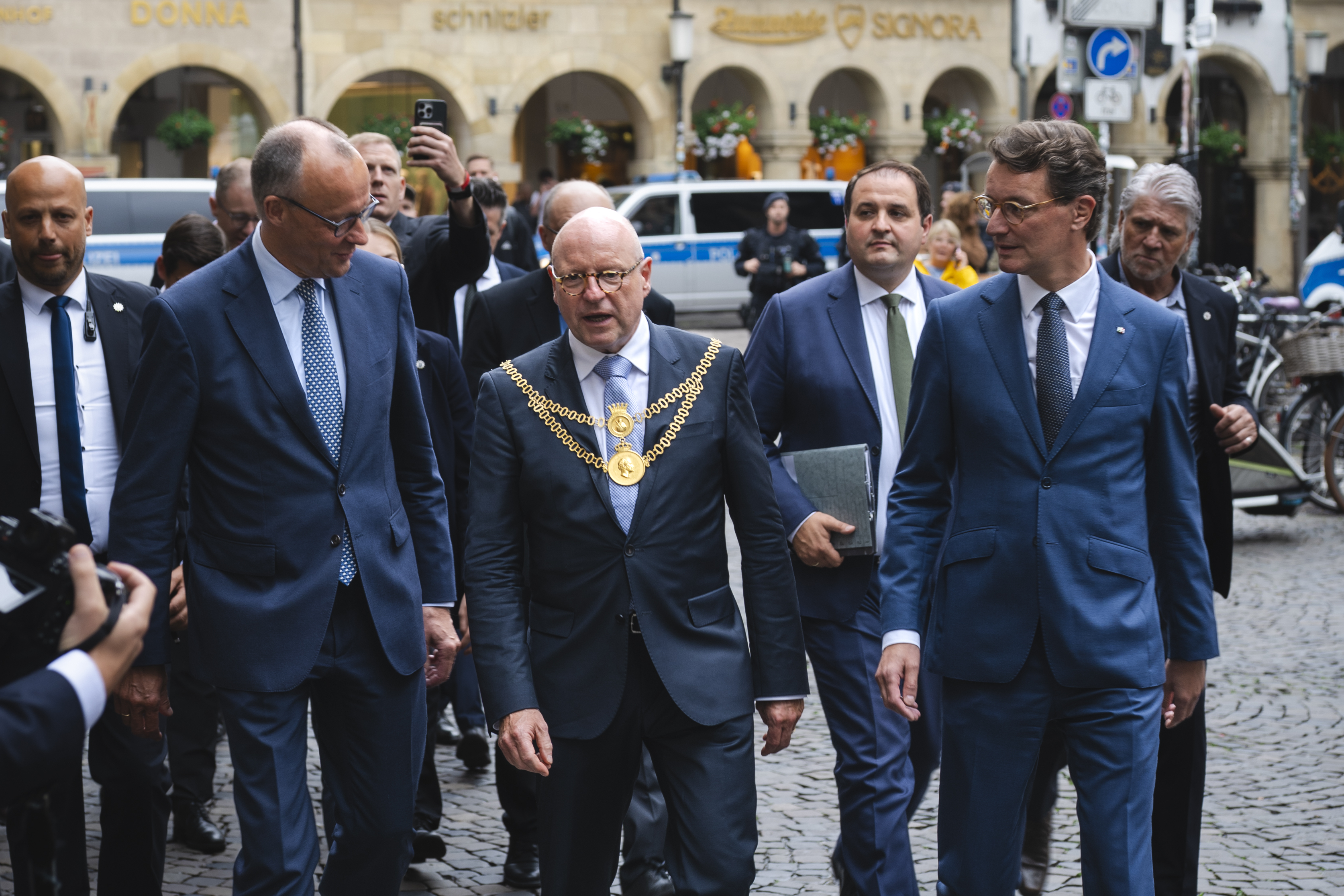 Oberbürgermeister Markus Lewe mit Bundeskanzler Friedrich Merz und Ministerpräsident Hendrik Wüst auf dem Prinzipalmarkt