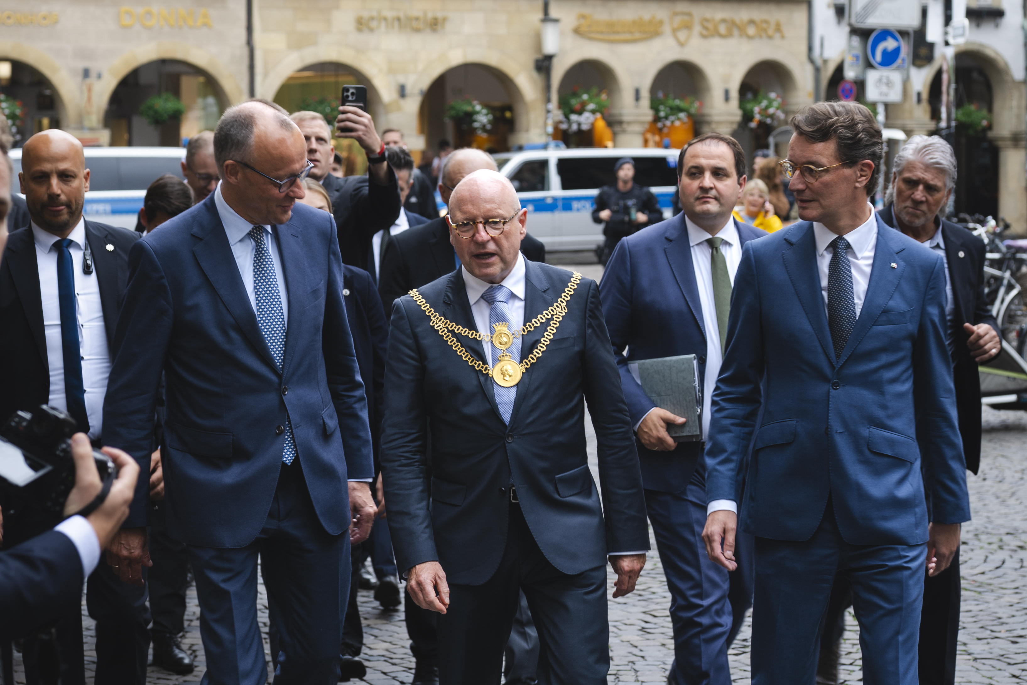 Oberbürgermeister Markus Lewe mit Bundeskanzler Friedrich Merz und Ministerpräsident Hendrik Wüst auf dem Prinzipalmarkt