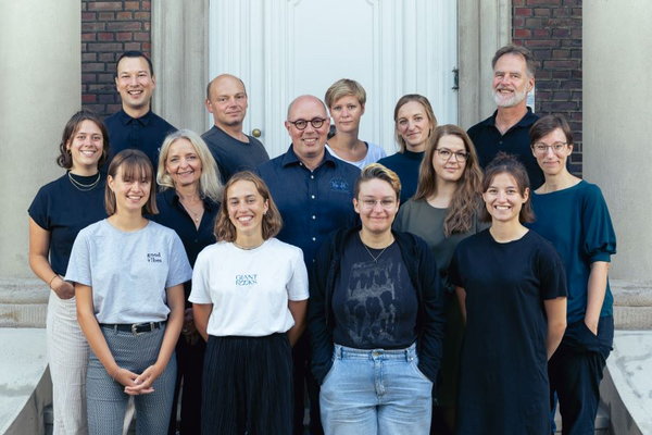 Vierzehn Mitarbeitende stehen in einem Gruppenfoto vor der Eingangstür der Villa ten Hompel