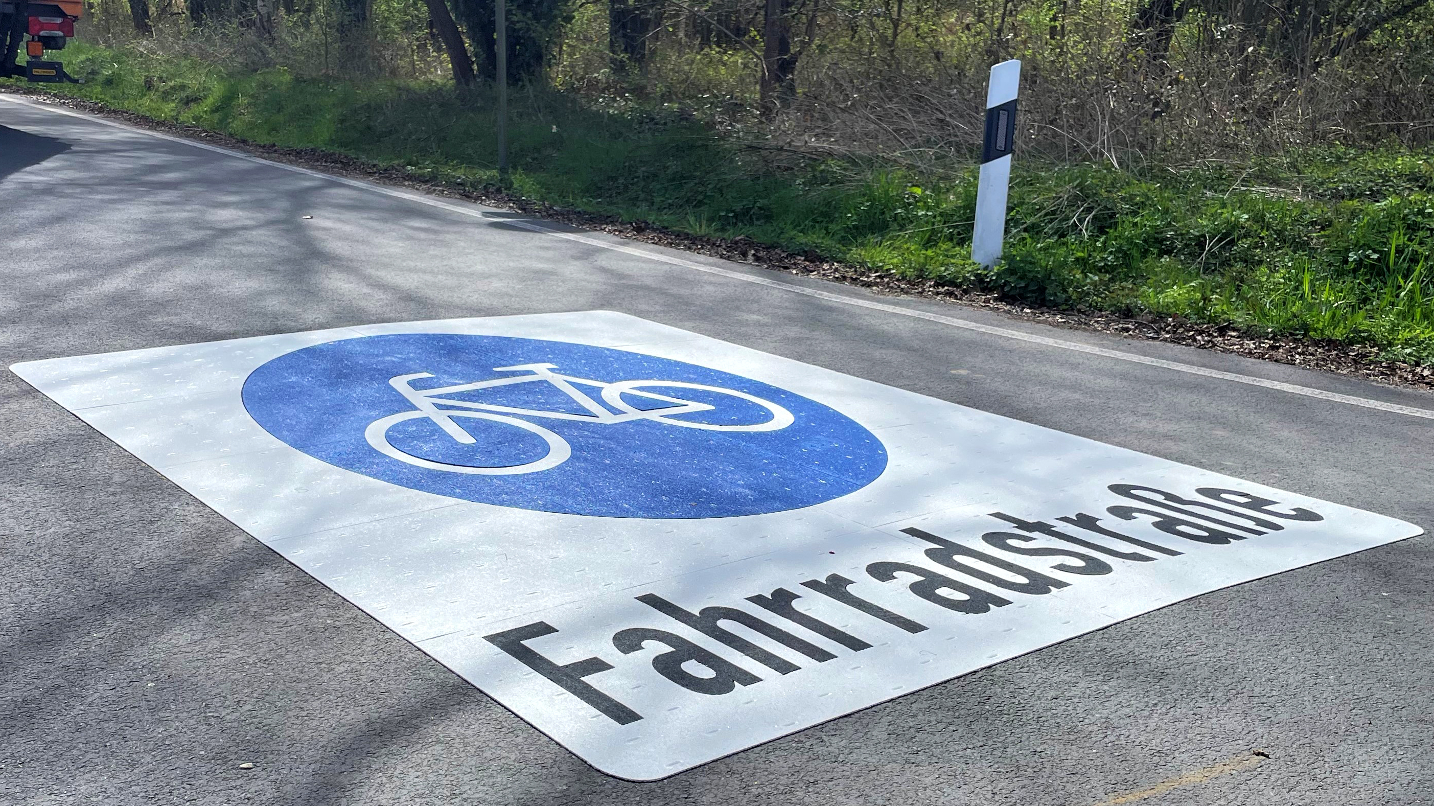 Der Hessenweg mit großem Fahrradstraßen-Piktogram, davor steht ein Baufahrzeug