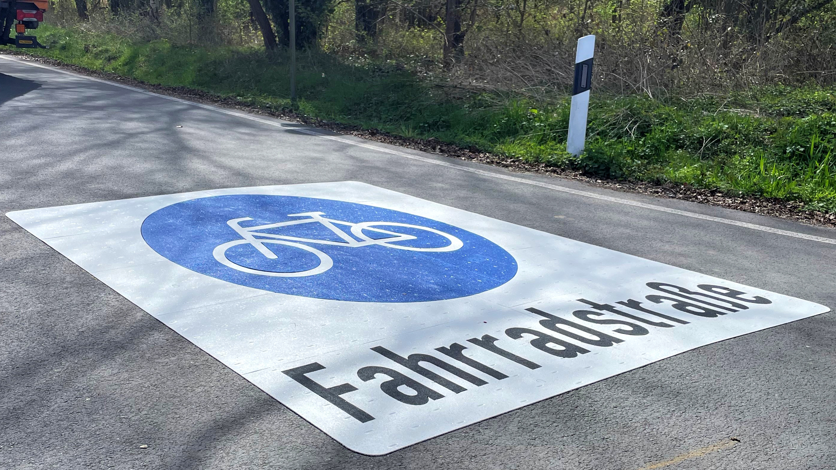 Der Hessenweg mit großem Fahrradstraßen-Piktogram, davor steht ein Baufahrzeug