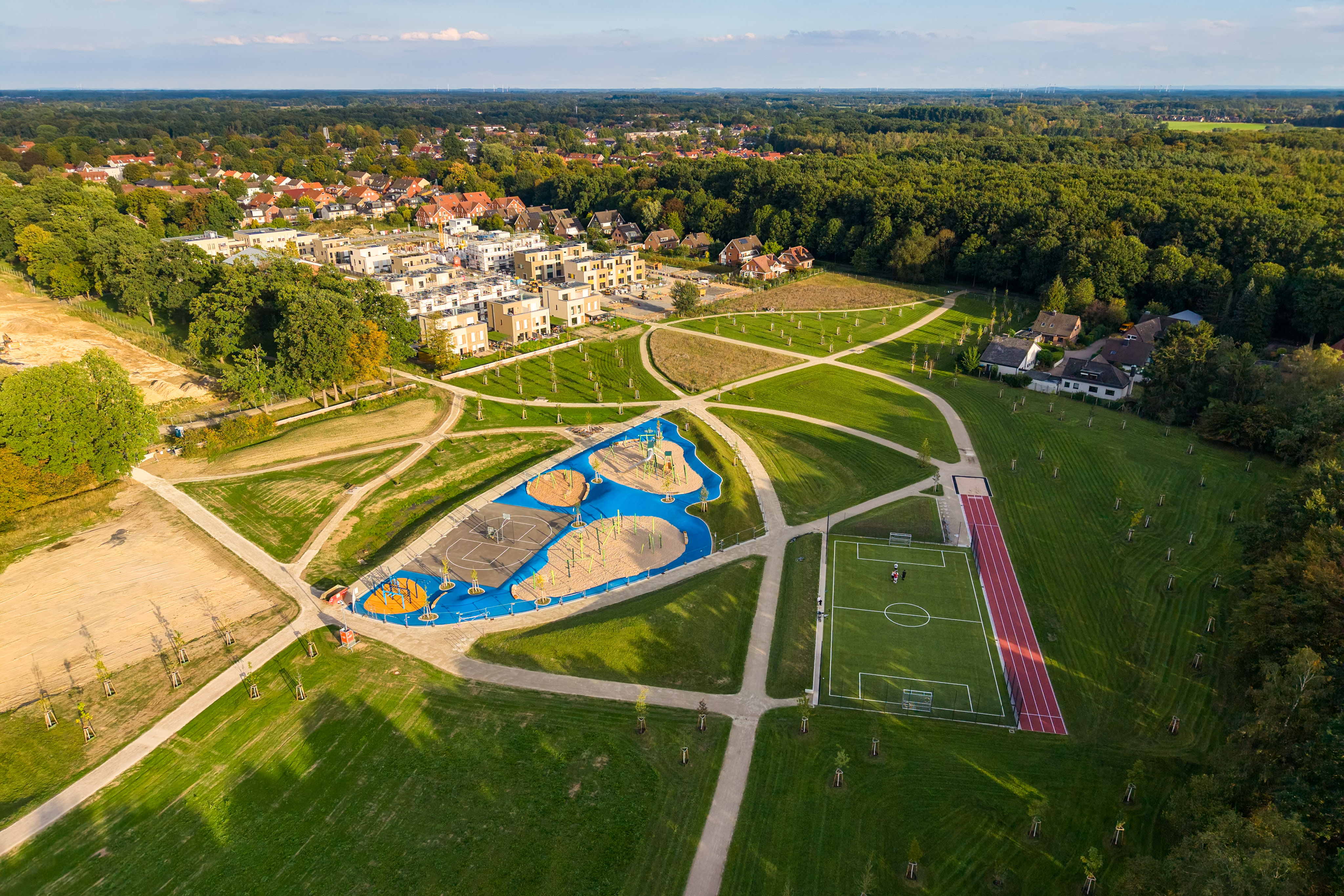 Drohnenaufnahme vom neuen Landschaftspark im York-Quartier: Große Wiesen, Sportanlagen und dazu ein Wald