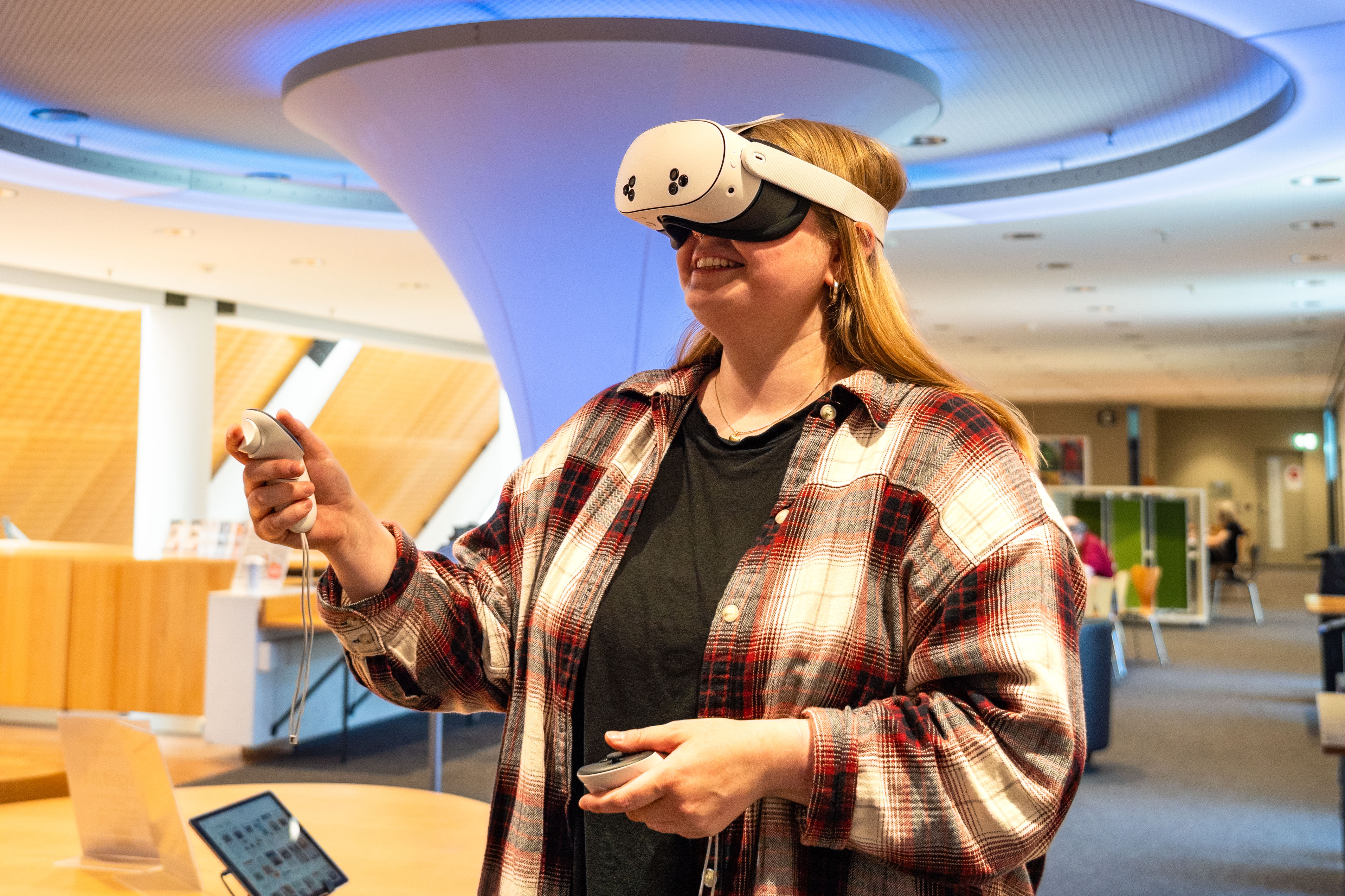 Junge Frau verwendet VR-Brille in der Stadtbücherei