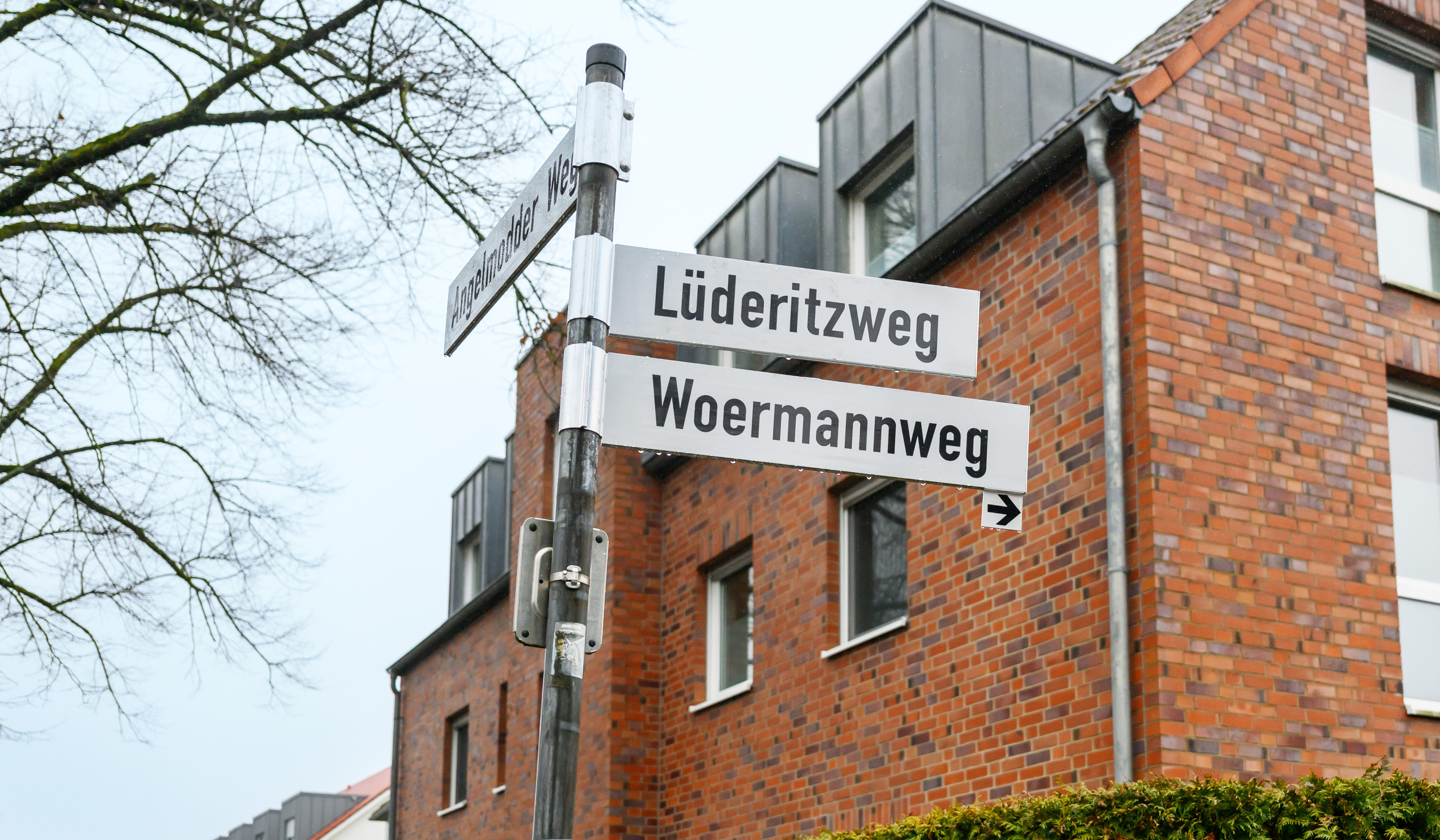 Strassennamenschild vom Lüderitz- und Woermannweg in Gremmendorf im Hintergrund ein Backsteinhaus