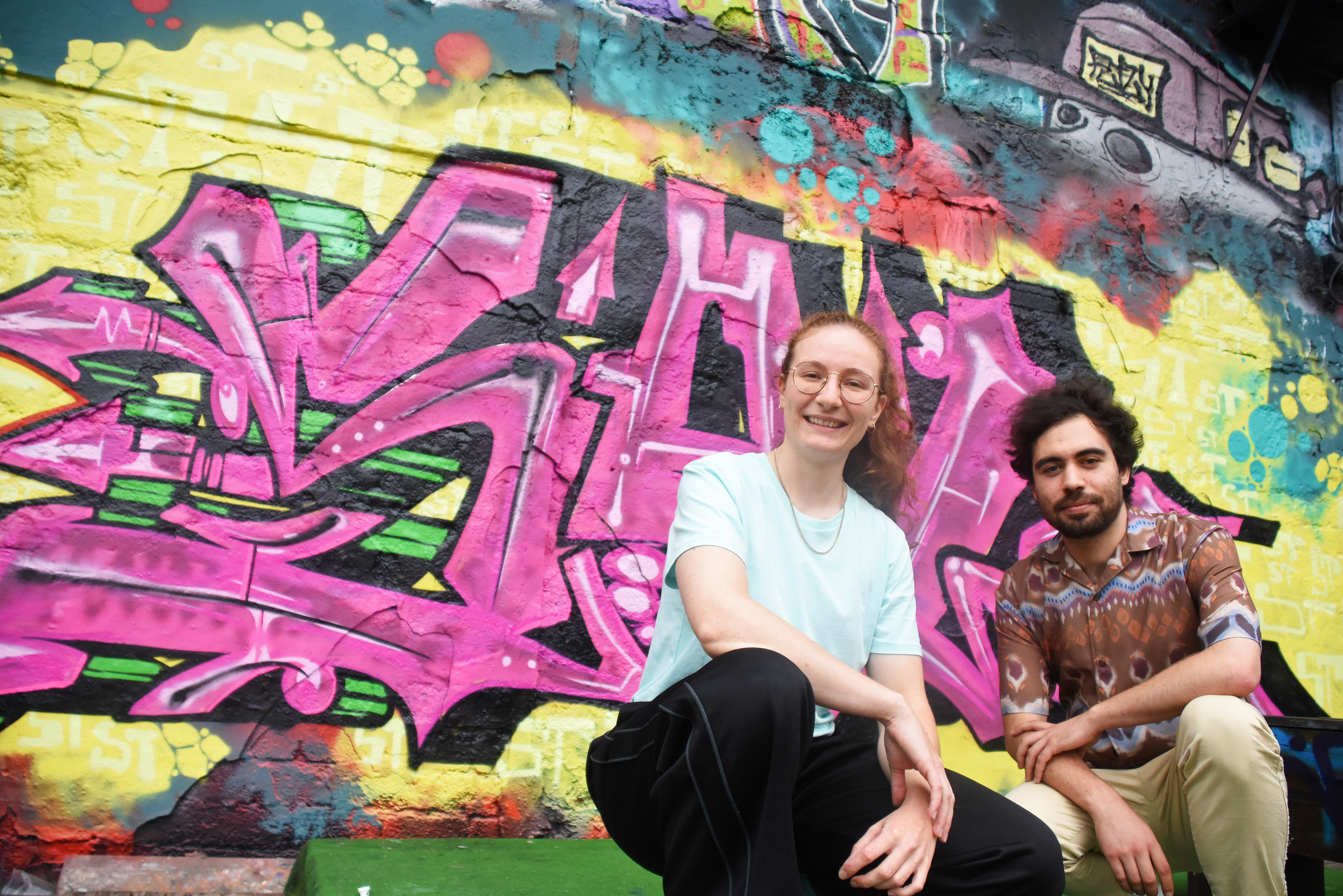 Das Nachtbürgermeister-Team Lisa Marie Tubies und Manuel Rojano Marin vor einer Wand mit Graffiti